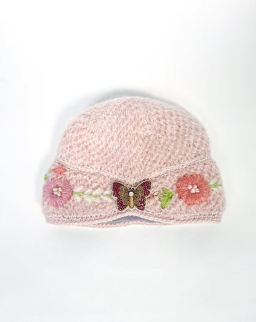 Adeline hand knit cloche hat with pink butterfly brooch.